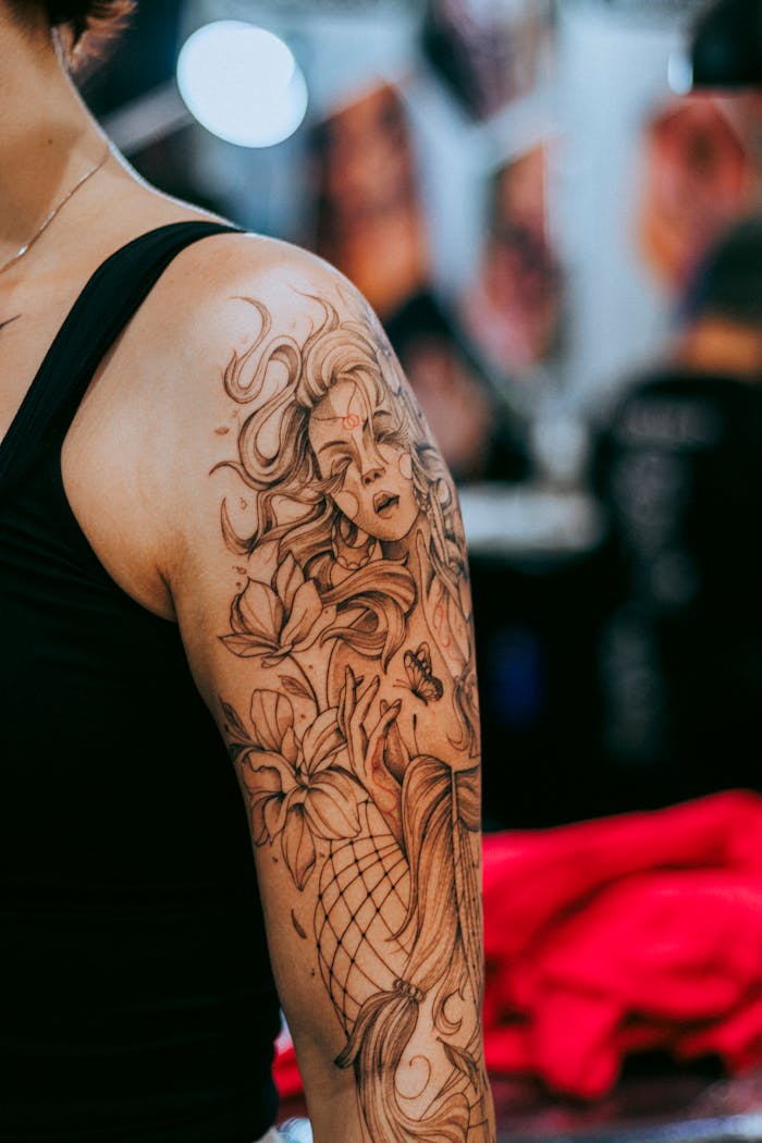 Crafting Captivating Headlines: Your awesome post title goes here Detailed arm tattoo featuring floral and mythical elements on a woman's shoulder.
