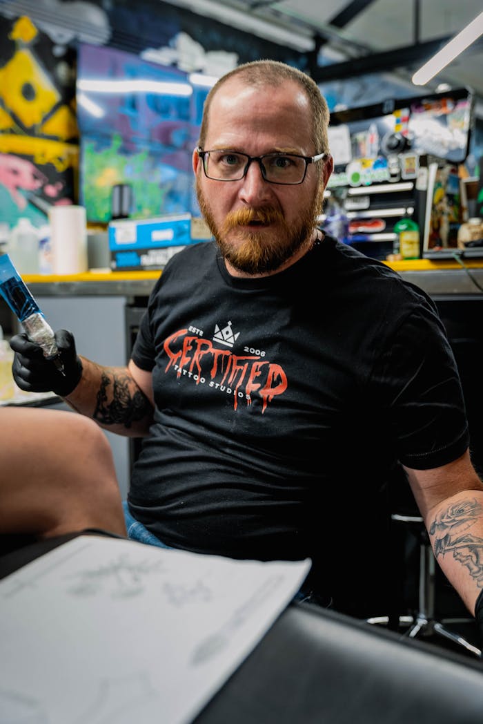 Mastering the First Impression: Your intriguing post title goes here A skilled tattoo artist focuses on creating a tattoo design in a vibrant studio setting.